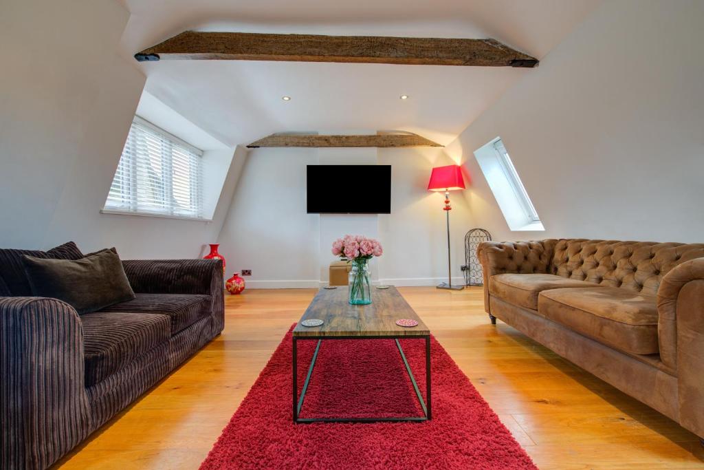 uma sala de estar com dois sofás castanhos e um tapete vermelho em Stylish Retreat - 2Bed Home with Exposed Beams em Stamford