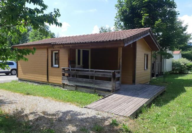 eine kleine Hütte mit einer Holzterrasse im Hof in der Unterkunft Camping Les Peupliers du Lac Onlycamp in Chindrieux