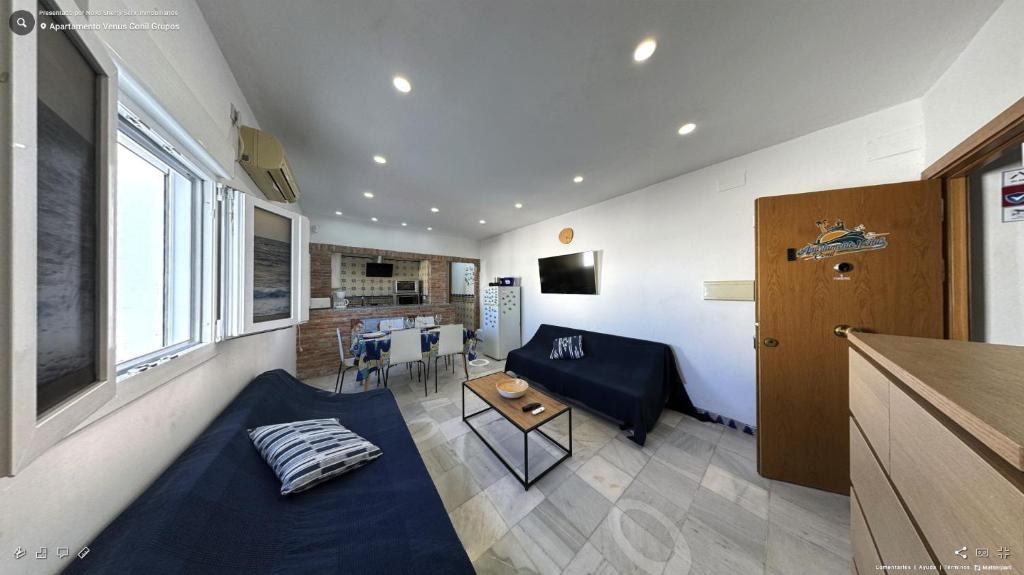 uma sala de estar com um sofá e uma mesa em Apartamento Venus Conil em Conil de la Frontera