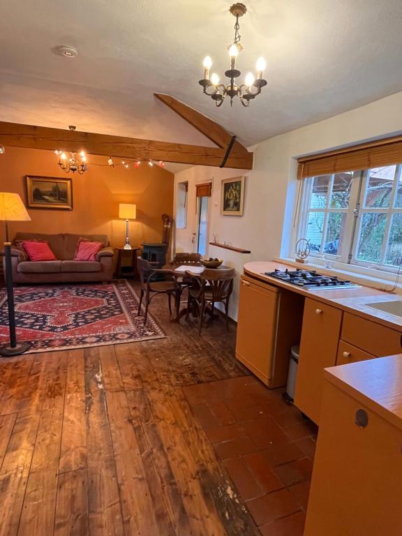 een keuken en een woonkamer met een bank en een tafel bij Hoeve de Knol in Holthees