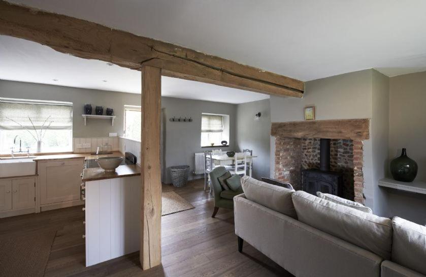 a living room with a couch and a kitchen at Samphire in Sharrington