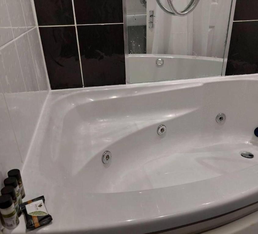 a white bath tub in a bathroom at 3-Bed House in Warrington in Warrington