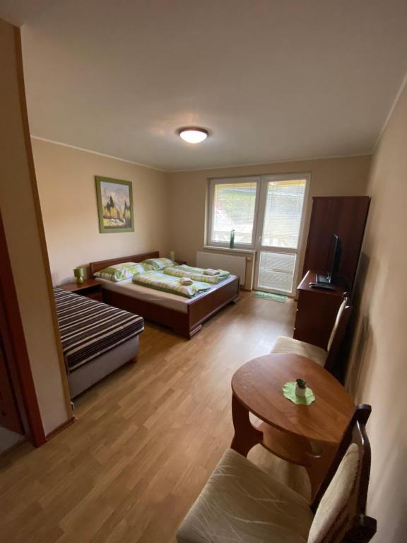 Cette chambre comprend 2 lits et une table. dans l'établissement Zamagurský dom, à Červený Kláštor