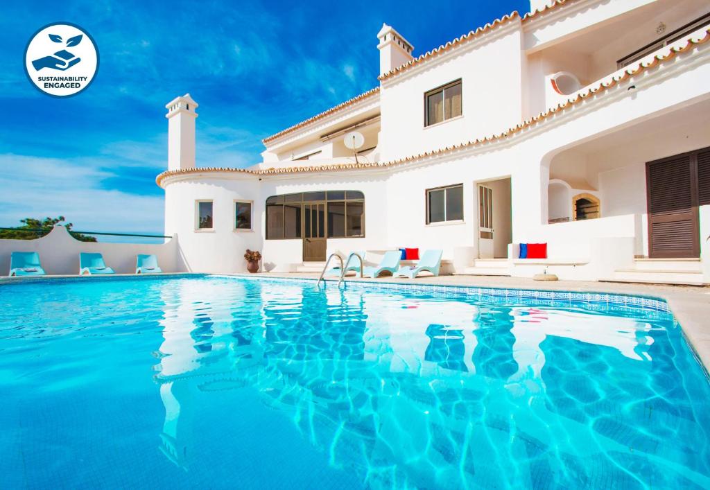a villa with a swimming pool in front of a house at Apartment Capri in Albufeira