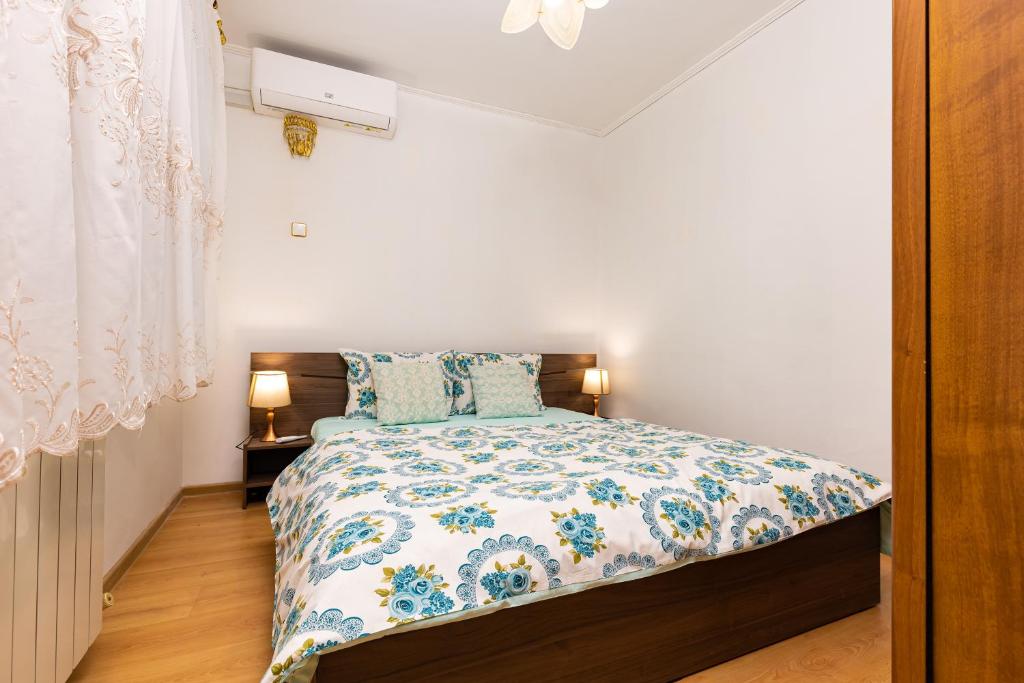 1 dormitorio con 1 cama con edredón azul y blanco en A Nostalgic Getaway in Plovdiv's Historic Quarter, en Plovdiv