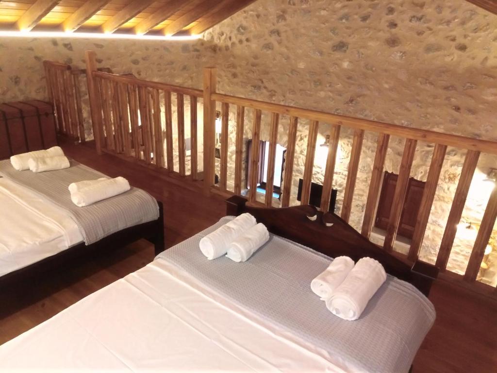 Habitación con 2 camas y toallas blancas. en Παραδοσιακός Ξενώνας Λυμπέρη, en Koíta