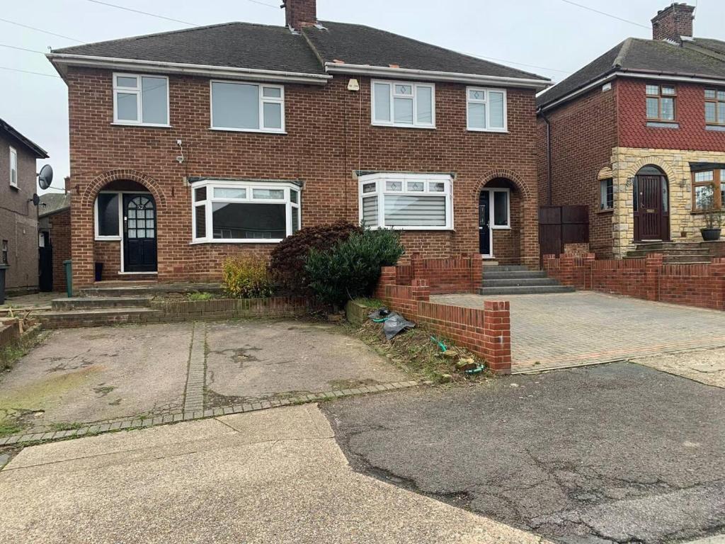 a brick house with a driveway in front of it at Lovely Contractor Family House London in London