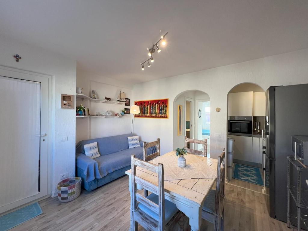 a living room with a table and a blue couch at La casa di Camilla in Cannigione