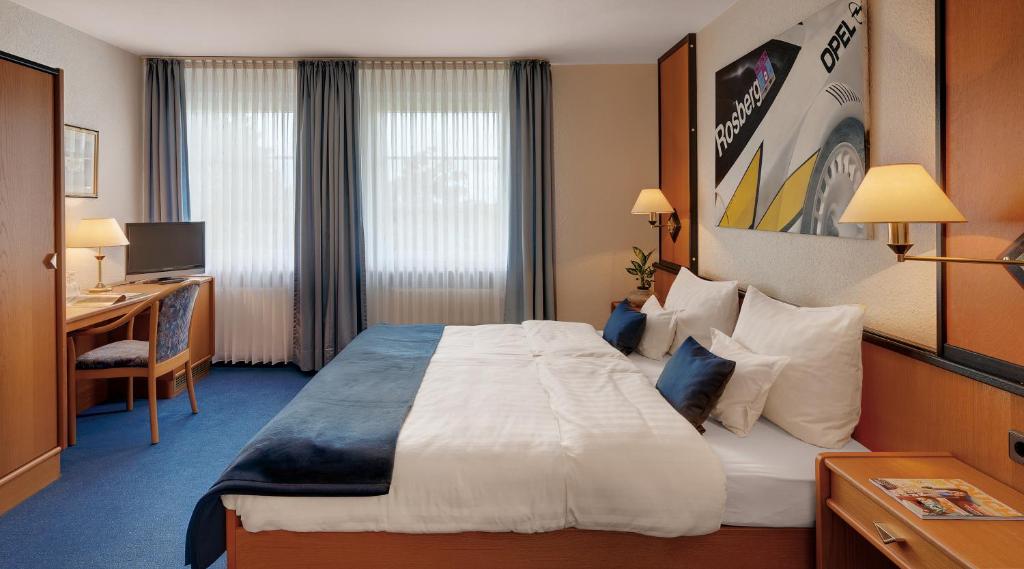 Postel nebo postele na pokoji v ubytování Motorsport Hotel