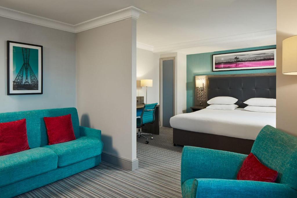 a hotel room with a bed and two chairs at Leonardo Hotel Middlesbrough in Middlesbrough