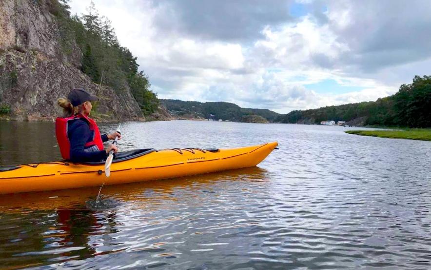 a woman in a yellow kayak on a river at Casa del Vika in Halden