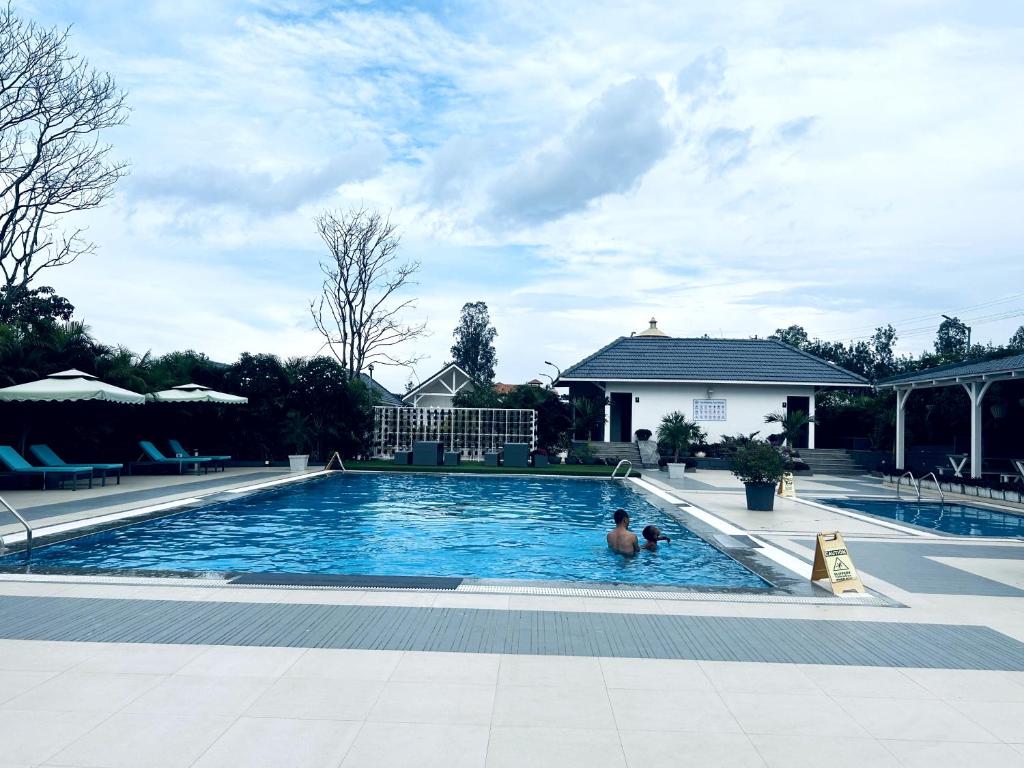 un hombre está nadando en una piscina en TVR Resort and Spa en Kushālnagar