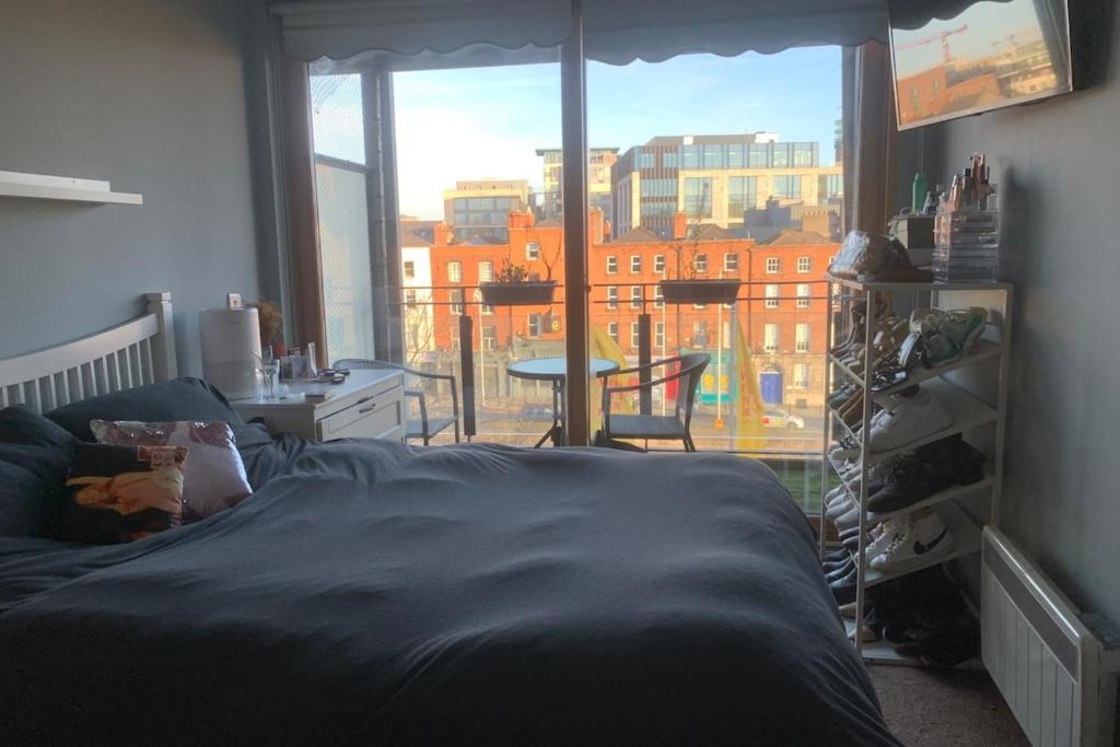 a bedroom with a bed and a large window at Chic & Radiant 1BD Flat near Dublin City Centre! in Dublin