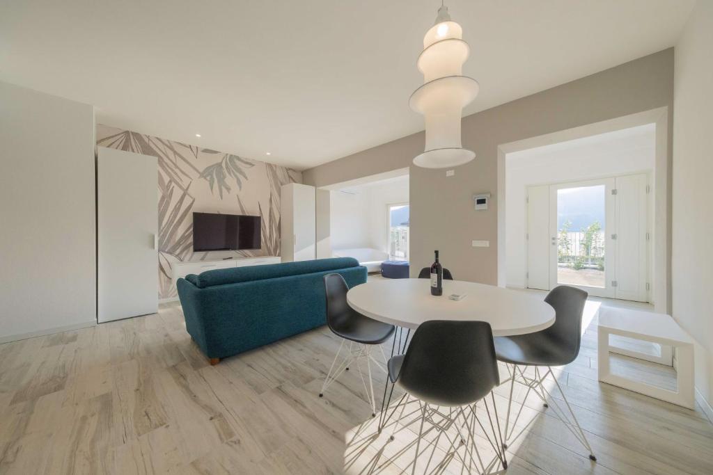 a living room with a blue couch and a table and chairs at ApartmentsGarda - L'Isola Blu in Garda