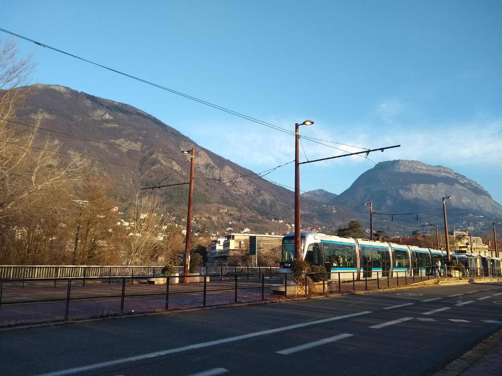 a train on the tracks with a mountain in the background at Colocation proche fac de médecine in La Tronche