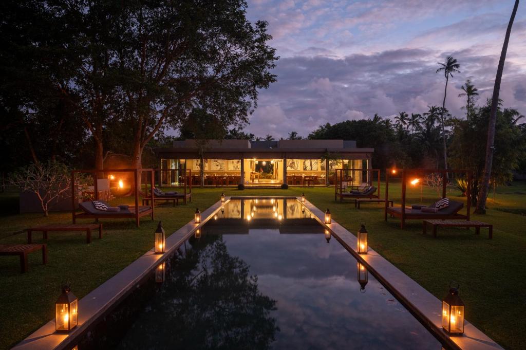 una casa con piscina e luci nel cortile di Wirdana Resort & Spa a Galle