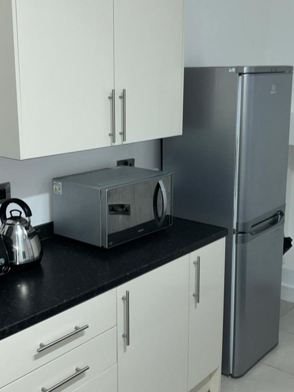 曼徹斯特的住宿－Lovely 1 bed apartment in Salford，厨房配有微波炉和冰箱。