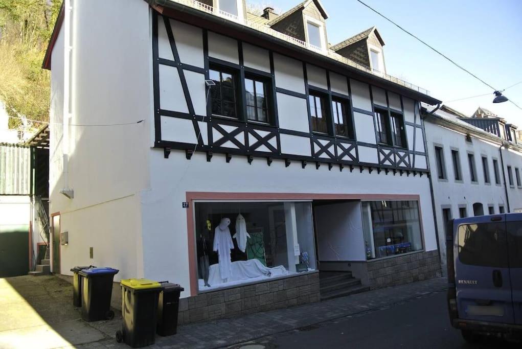 a white building with two mannequins in a window at Wohnung am Georgstor Blankenheim in Blankenheim