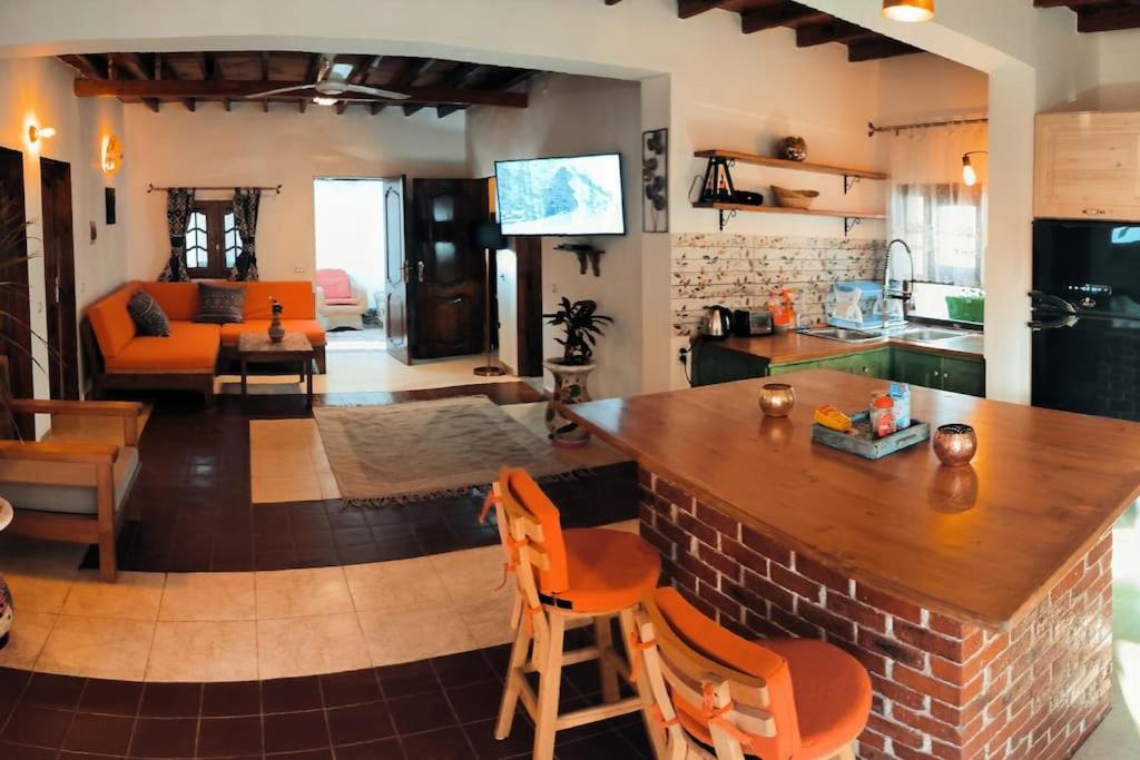 a kitchen and living room with a bar in a room at Shanti Garden House in Dahab