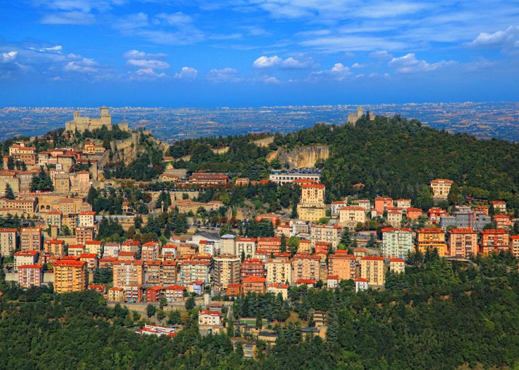 une ville au sommet d'une colline avec des bâtiments dans l'établissement La Famosa Dimora Ambasciatore, à Saint-Marin