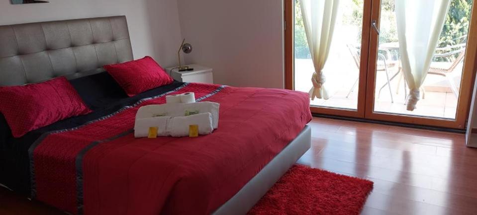 a bedroom with a red bed with a teddy bear on it at AL "Villa Por Do Sol" Sunset Olhão in Olhão
