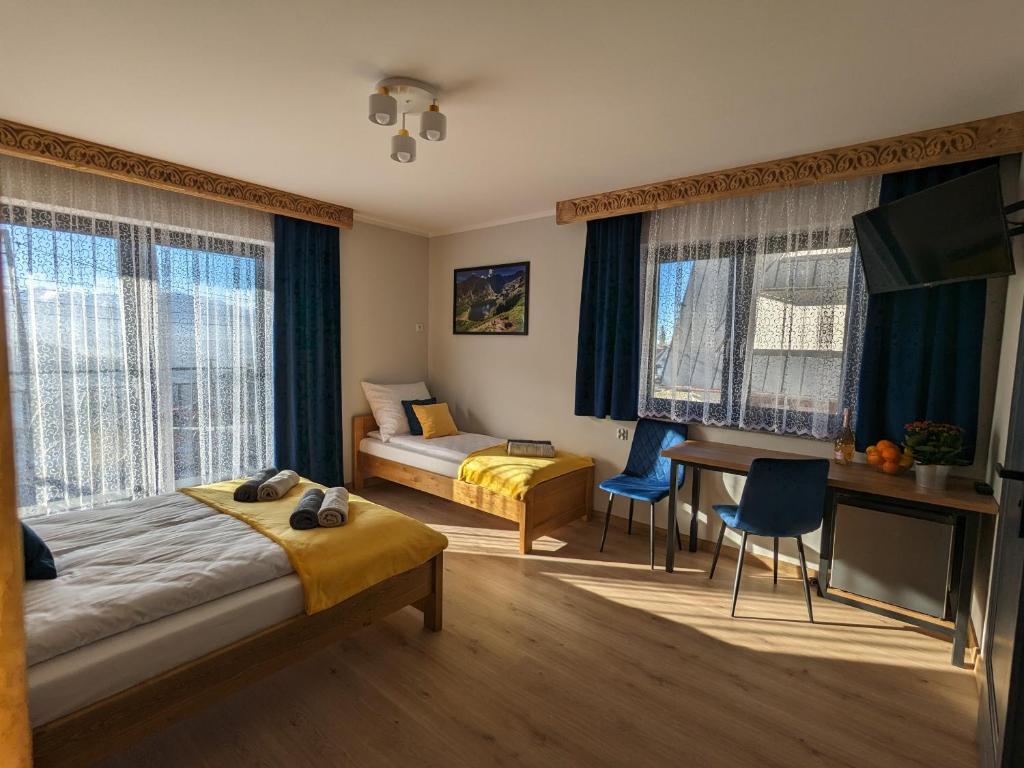 Habitación de hotel con cama, escritorio y cama en Willa Janowa, en Bukowina Tatrzańska