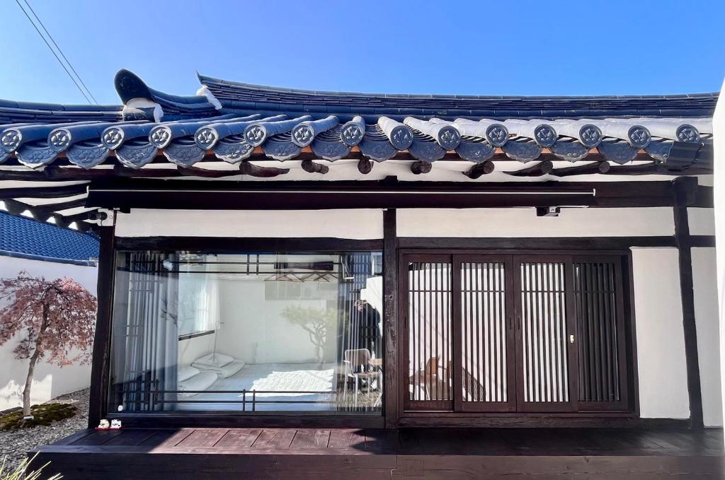 um edifício com uma porta de vidro e um telhado em Hanok Dasi Bom em Gyeongju