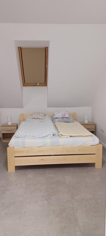 a wooden bed in a room with aermott at Atkacs Home in Győr