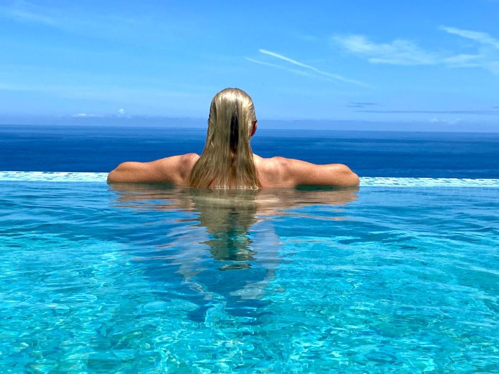 a woman in the water in the ocean at Villa Oasis La Paz - Romen Studio - ADULTS ONLY in Puerto de la Cruz