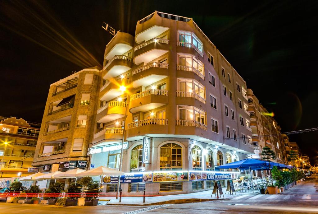 a tall building with lights on in front of it at Hotel Mediterráneo in Guardamar del Segura