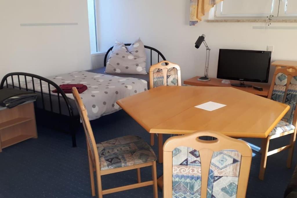 a room with a table and a bed and a desk at Ferienwohnung Hirschgrundblick in Oberlungwitz