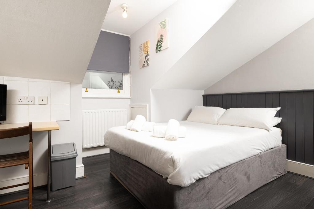 a bedroom with a large white bed and a desk at Charmstay Swiss Cottage in London