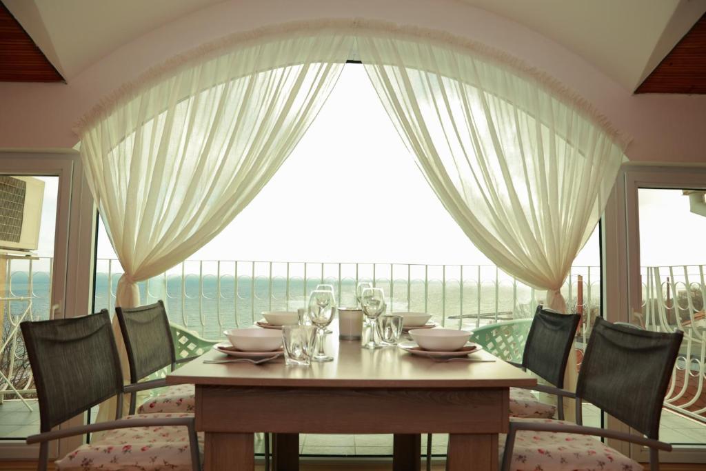 a dining room with a table and a large window at Апартаменти Дача in Varna City