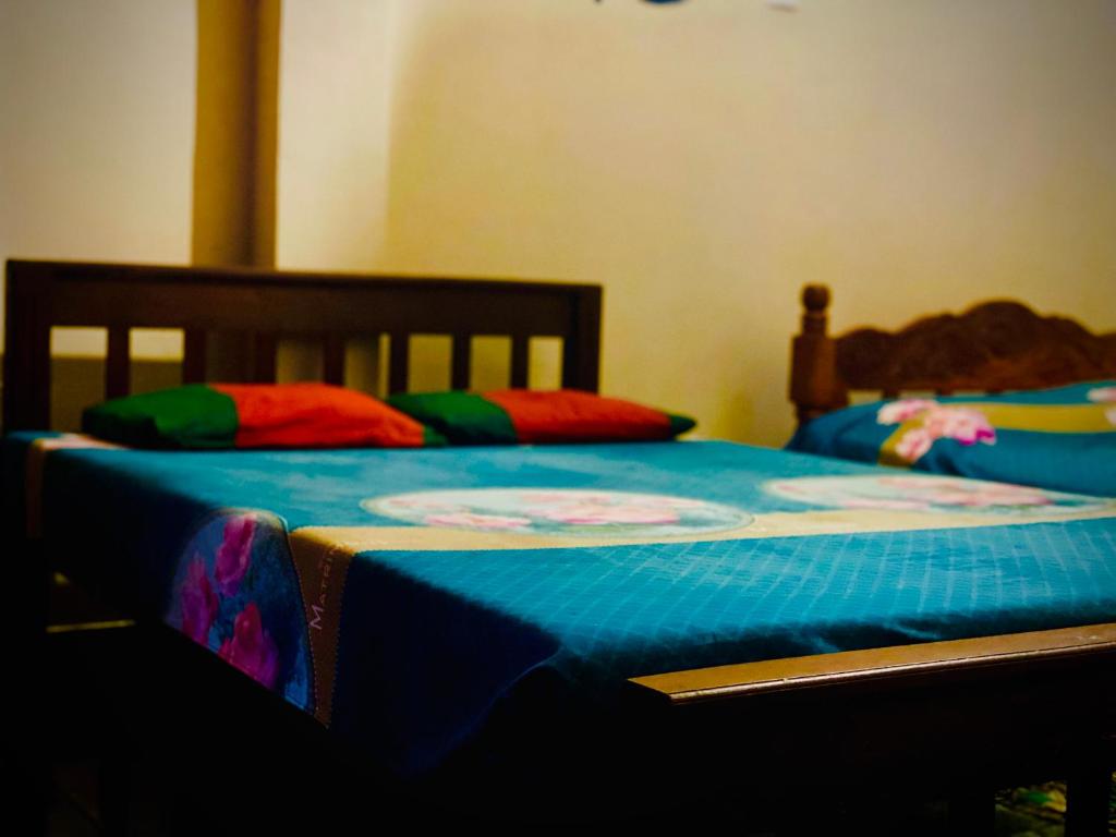 2 Einzelbetten in einem Schlafzimmer mit einer blauen Decke in der Unterkunft Residence Inn in Angunakolapelessa