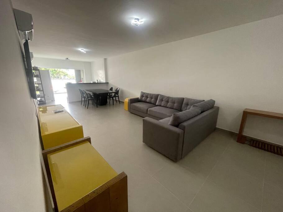 uma sala de estar com um sofá e uma mesa em Lindo apartamento Ubatuba em Ubatuba