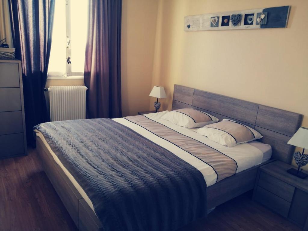 um quarto com uma cama grande e 2 almofadas em Appt ENTIER proche *CENTRE VILLE *GARE em Sainte-Savine