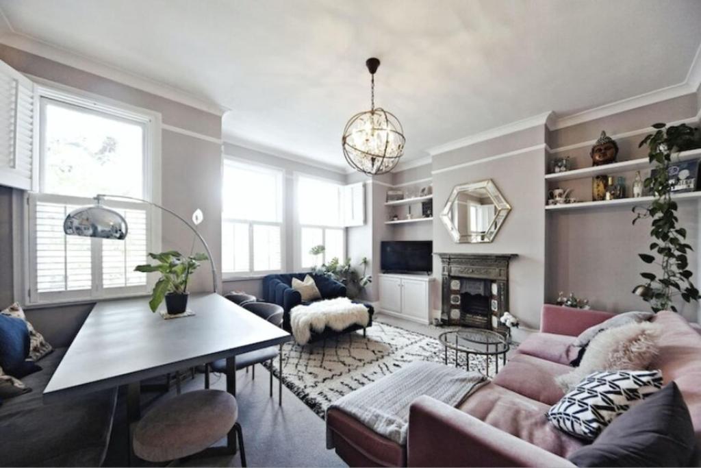 sala de estar con sofá y mesa en Chic 3BD Maisonette wRoof Terrace - Wandsworth!, en Londres