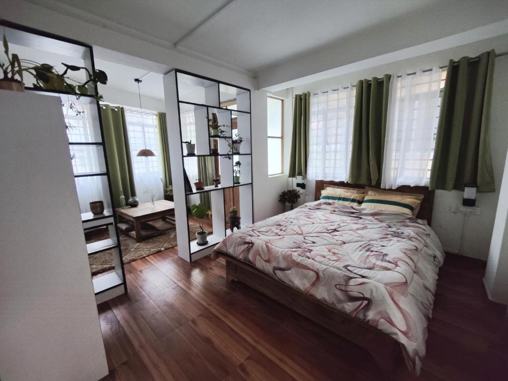1 dormitorio con 1 cama grande y espejo en Ivory Botanic Stay en Darjeeling