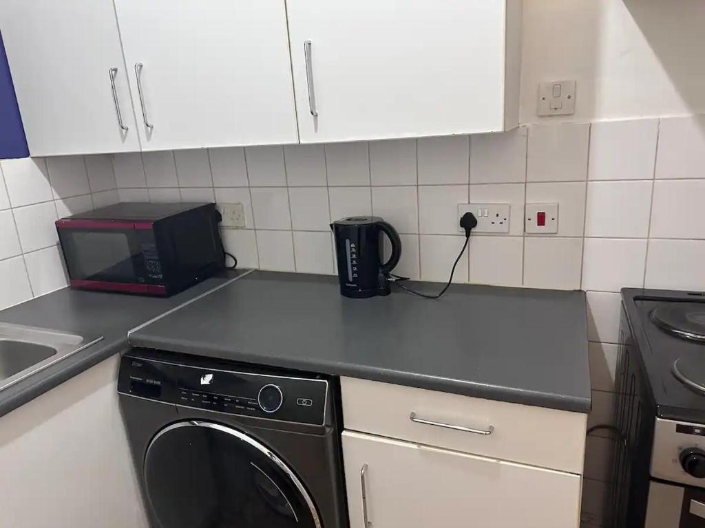 a kitchen counter with a microwave and a dishwasher at Goswell Road Studio for 3 - Central London Retreat in London