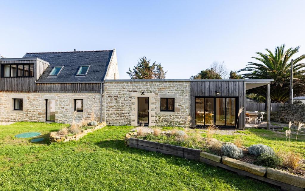 una casa de piedra con un gran patio en Maison pour 4 personnes proche de La Torche en Plomeur