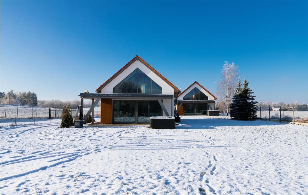 a house in the snow with a snow covered yard at Beautiful Home In Ryn With House A Panoramic View in Ryn
