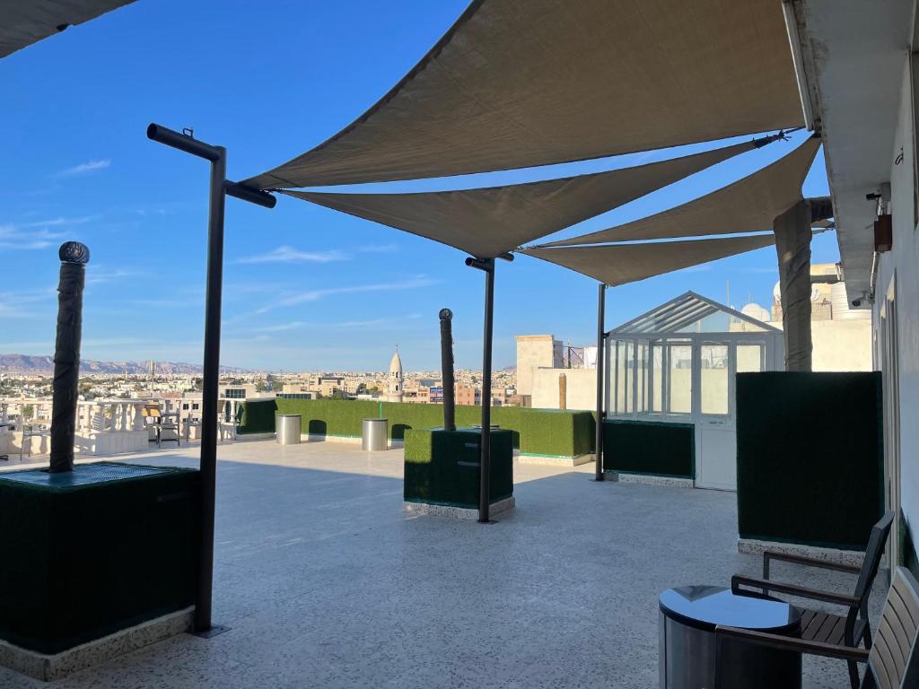 a patio with a canopy and a view of the city at Dweik Rooftop in Aqaba