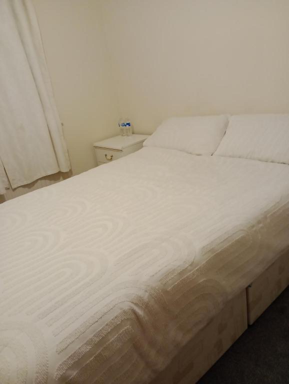 a white bed in a room with a window at Milton Keynes Lettings in Milton Keynes