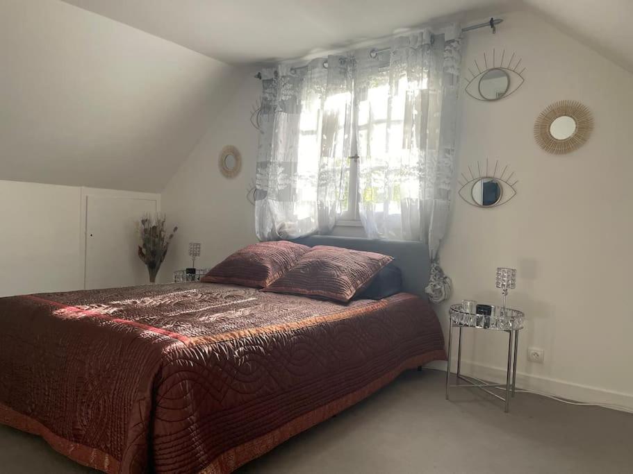Schlafzimmer mit einem Bett und einem Fenster in der Unterkunft BY NEPTUNE - La Villa Courtenay Piscine Privée in Courtenay