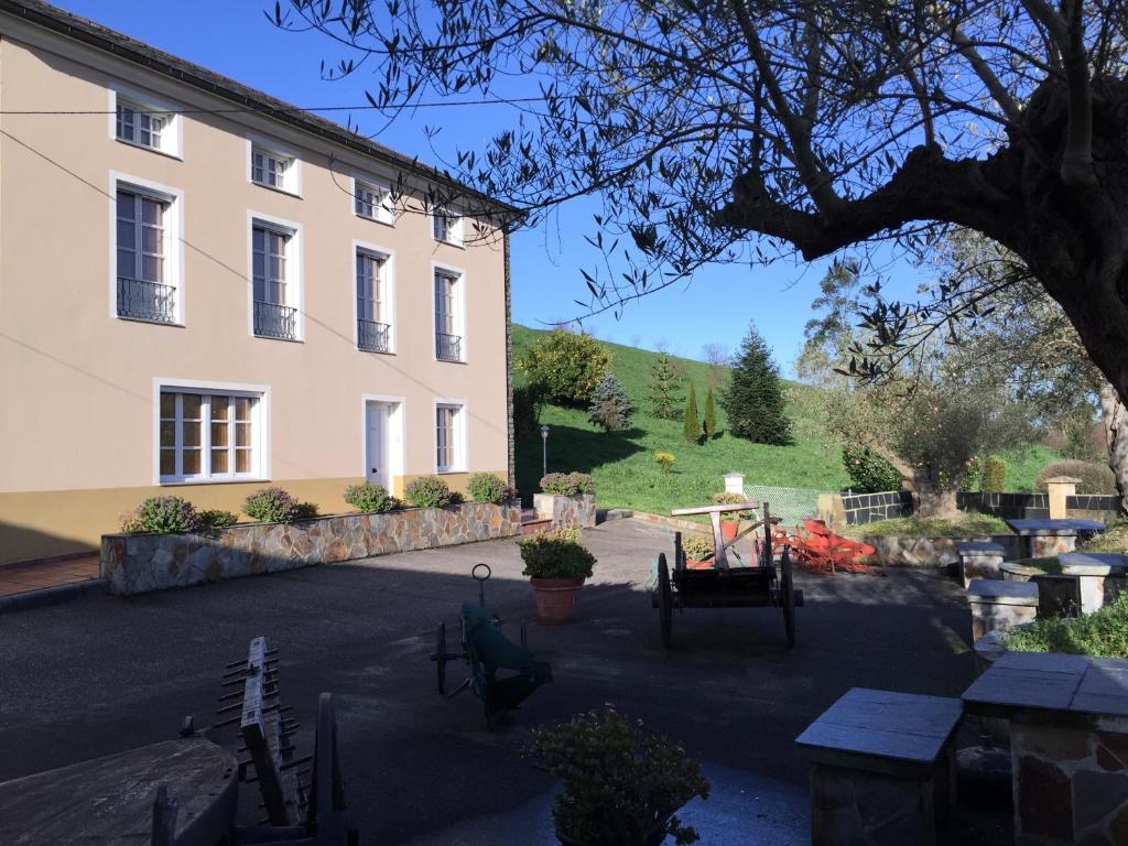 a large white building with a table in front of it at Apartamentos Rurales Casa Ron in Coaña