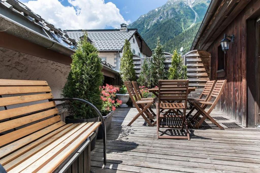 een terras met houten banken en een tafel en stoelen bij 90m2 hypercentre, terrace, next to ski lift in Chamonix-Mont-Blanc