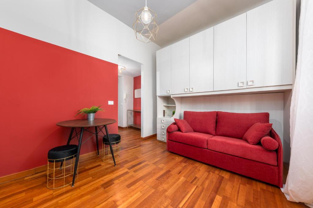 ミラノにあるCasa da Suite Arcoのリビングルーム(赤いソファ、テーブル付)