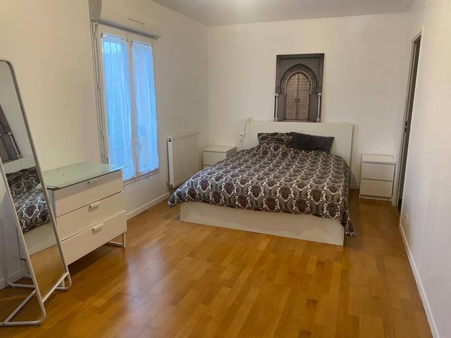 ein Schlafzimmer mit einem Bett und einer Kommode darin in der Unterkunft Maison 4 CHAMBRES St Pierre du Perray, France in Saint-Pierre-du-Perray