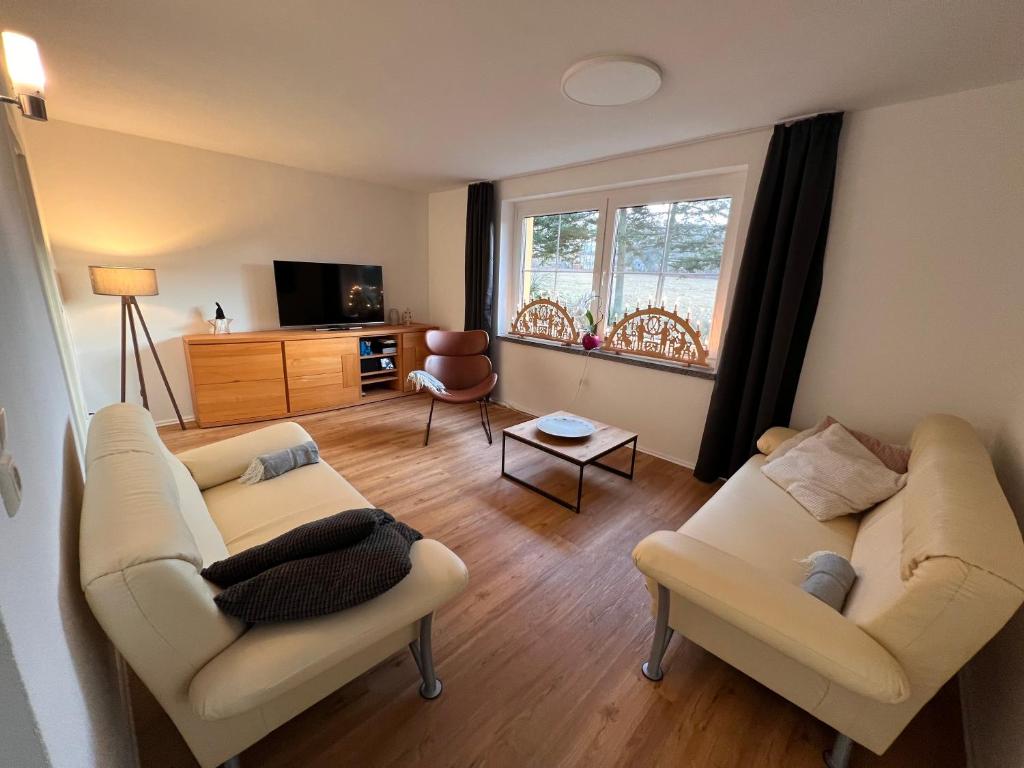 ein Wohnzimmer mit 2 Sofas und einem Fenster in der Unterkunft Ferienhaus Bergblick - mit Sauna und Dampfbad und Yacuzzi in Sehma