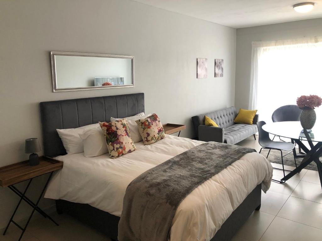 een slaapkamer met een bed en een woonkamer bij OAM The View Morningside in Johannesburg